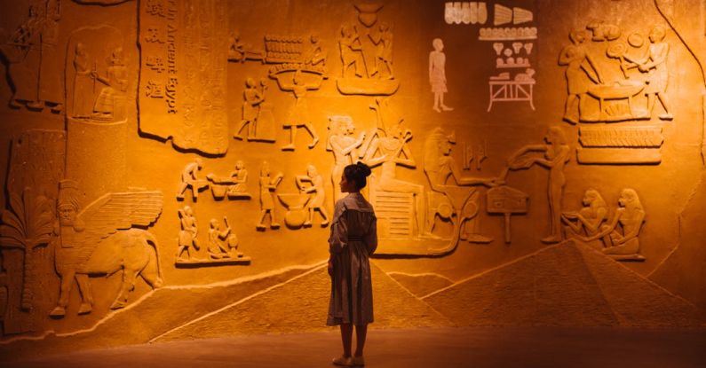 Wi-Fi Encryption - Back view of anonymous female traveler standing near ancient wall with Egyptian engraving