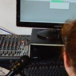 Software Updates - Unrecognizable sound engineer installing software on desktop computer at home