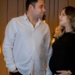 Viral Content - A pregnant couple standing in front of a lighted wall